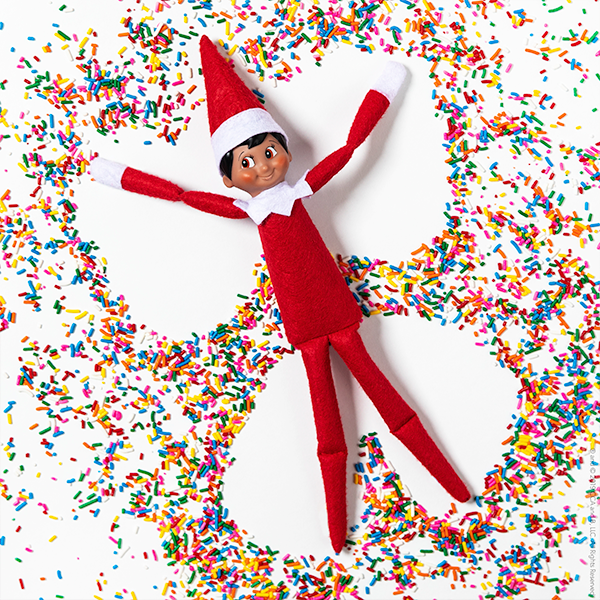 Elf making snow angel in sprinkles