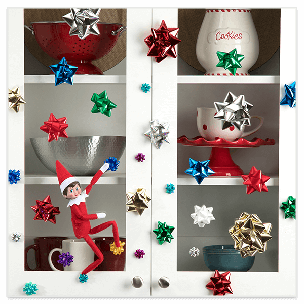 Scout elf climbing cabinet on gift bows