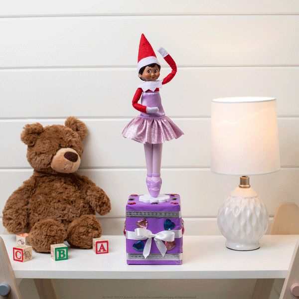 Elf with magical standing tutu outfit on top of music box