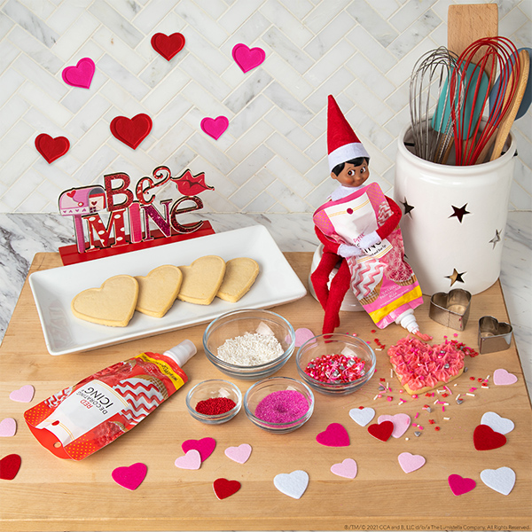 Elf with heart cookies and decorating materials