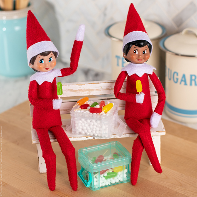 The Elf on the Shelf and friend enjoy elf-sized popsicles made of candy and toothpicks.