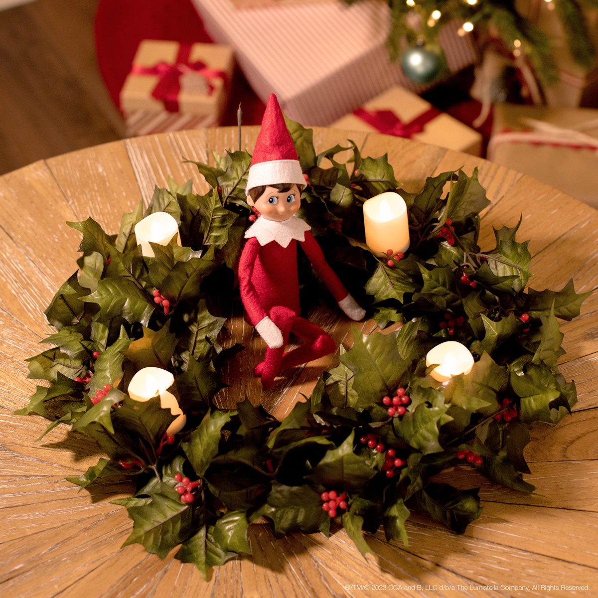 The Elf on the Shelf sitting in an advent wreath with four flameless candles.  
