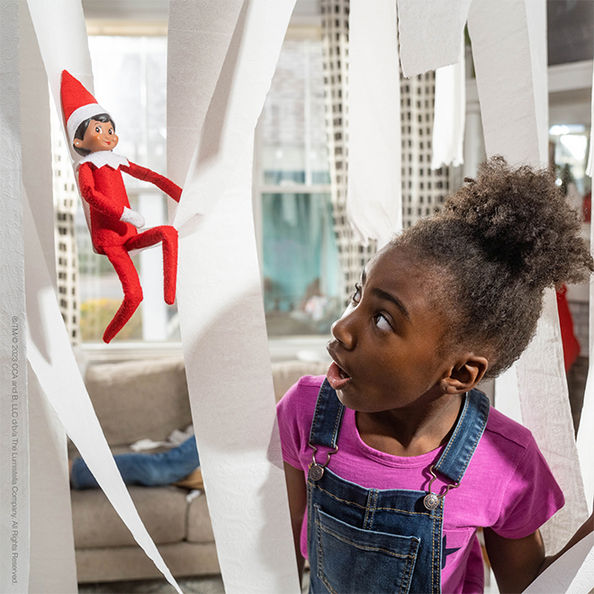 The Elf on the Shelf wrapped in toilet paper after just wrapping a whole room in toilet paper as a funny elf idea.