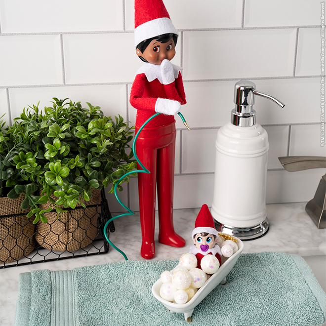 Scout Elf pretends to giv a Frost Pips a shower