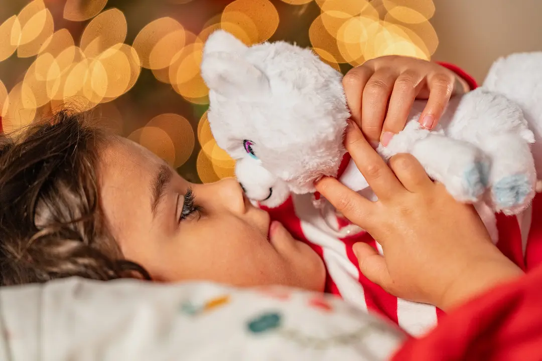 Young girl hold the Elf Pets fox cub nose to nose as she goes to sleep