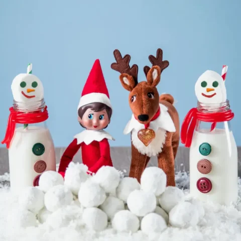 The Elf Pets Reindeer sits beside The Elf on the Shelf and two snowmen with marshmallows to create an elf idea