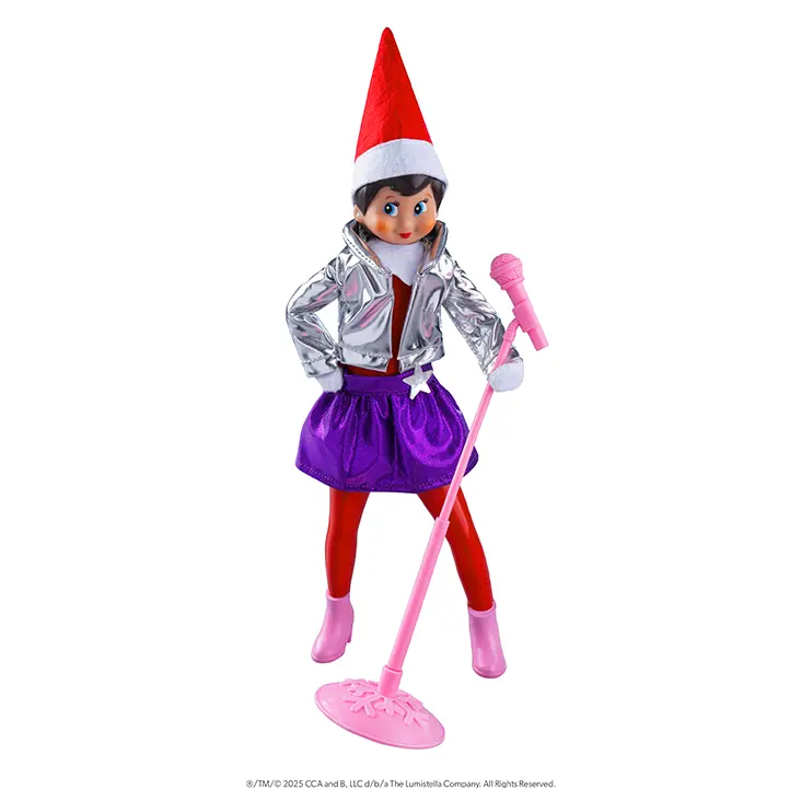 Scout Elf girl with light skin and blue eyes wearing the Pop Star outfit. She has her right hand on her hip and the microphone stand in her left.