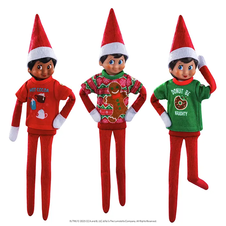 Three Scout Elves, a girl with dark skin and brown eyes, a boy with light skin and blue eyes, and a girl with light skin and blue eyes, each wearing a t-shirt in the Festive Fun T-Shirt Set.