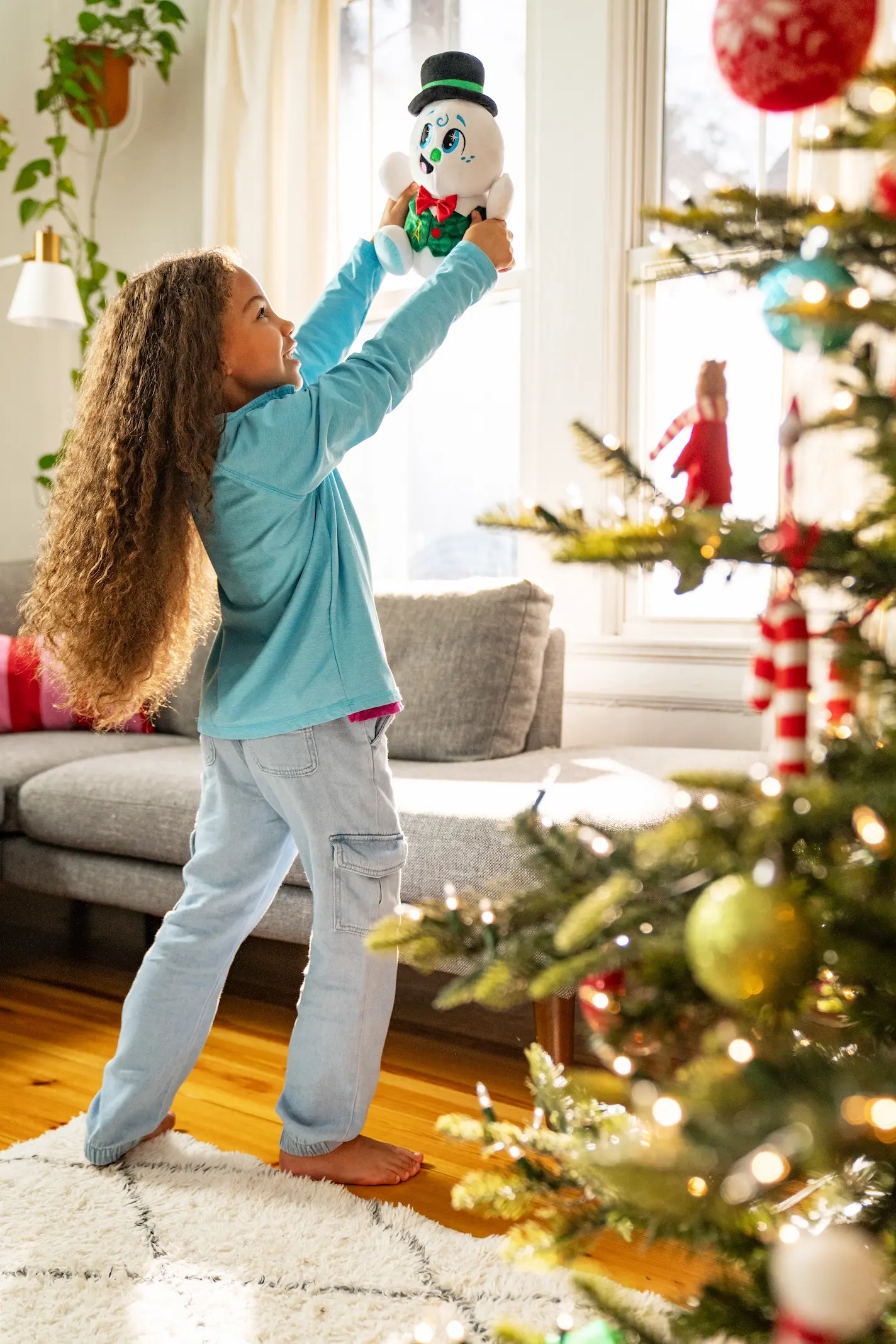 Young girl with curly hair holds Razzle high in the air while dancing with him