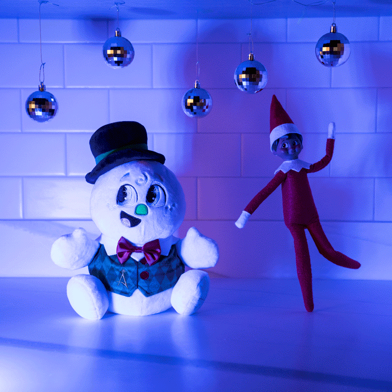 GIF shows Razzle and Scout Elf beneath mini disco balls while lights flash on dance floor