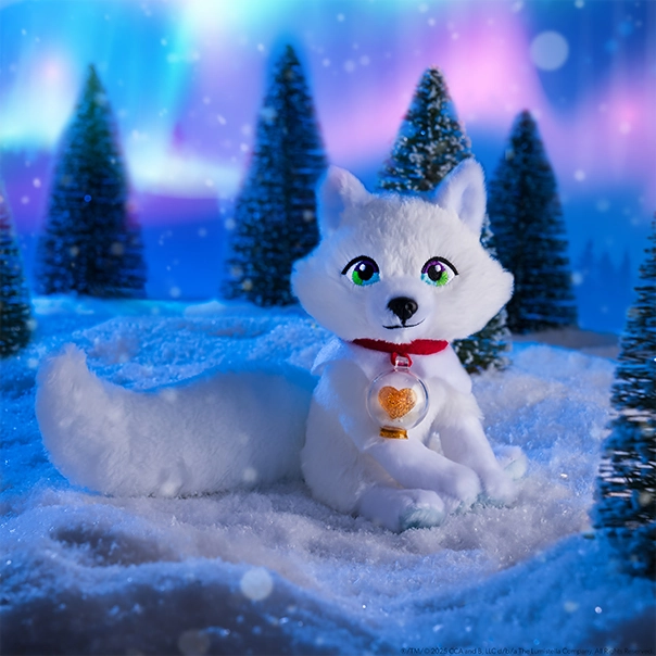 The Elf Pets® Arctic Fox plush posing in a magical, snowy setting with conifer trees in the background and the Northern Lights overhead.