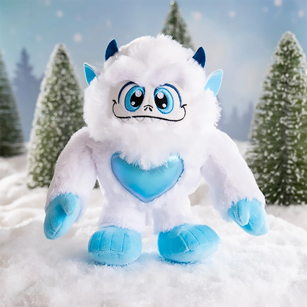 A SnoBiggie™ Yeti Little Grunt Plush posing in a magical snowscape with conifer trees in the background.