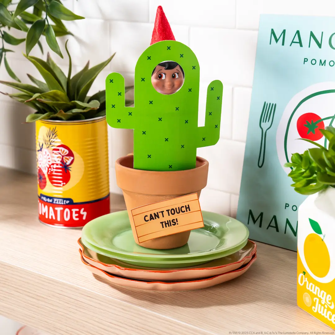 The Elf on the Shelf stands behind a printable cactus with a sign that says, "Can't Touch This!"