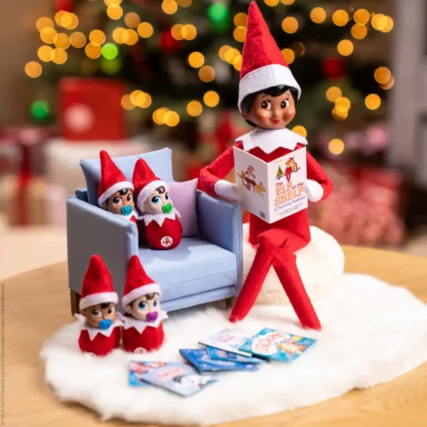A Scout Elf sits beside four Frost Pips elf babies reading books to them.
