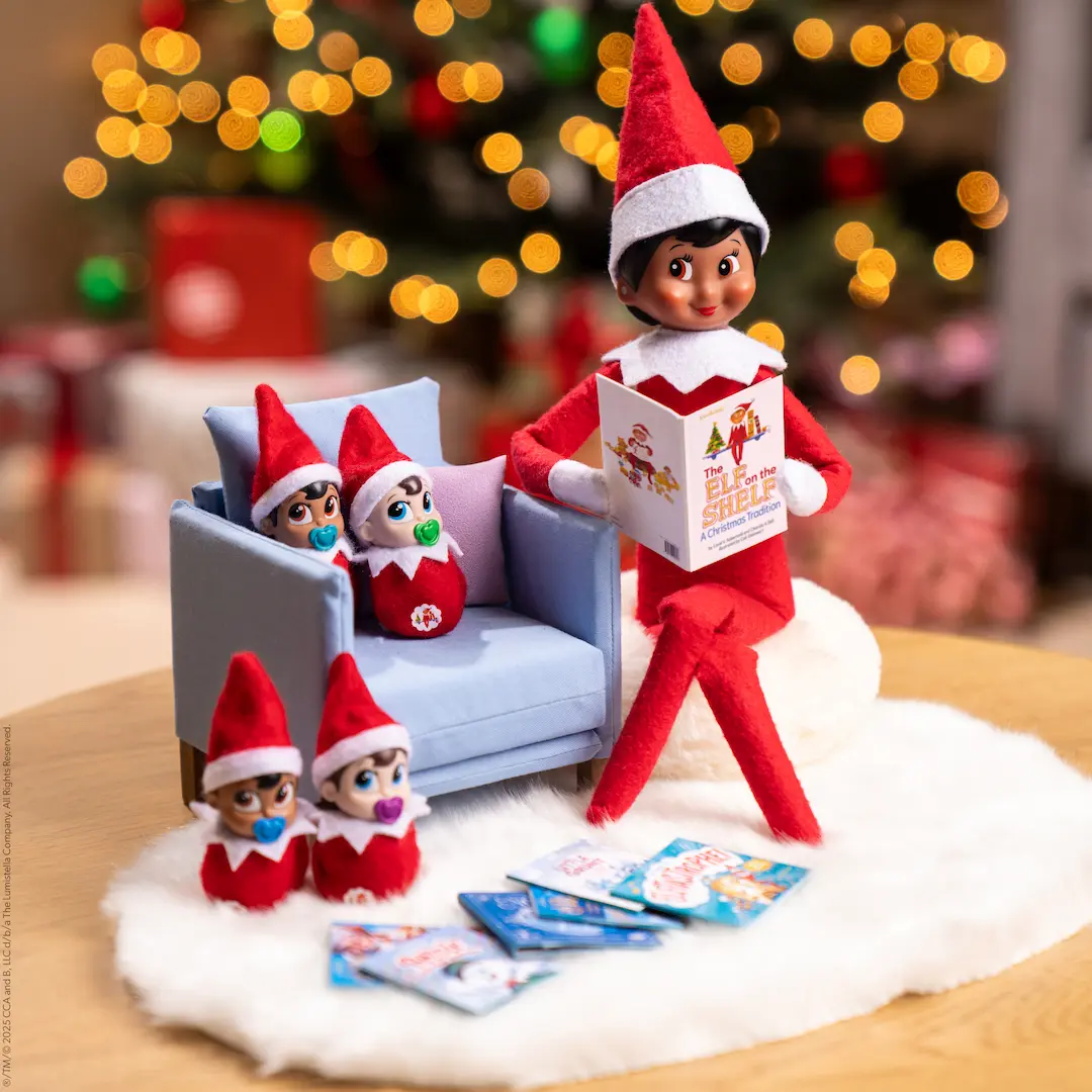 A Scout Elf sits beside four Frost Pips elf babies reading books to them.