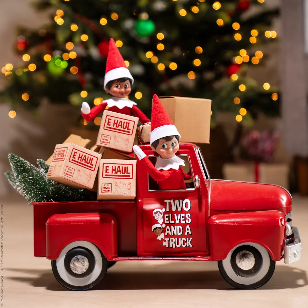 Two Scout Elves drive a truck full of moving boxes