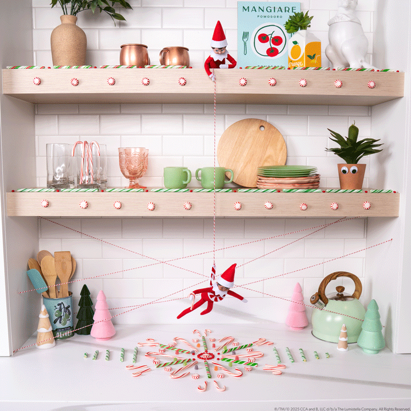 A GIF showing one elf holding a candycane striped rope while the other elf descends as if rappelling to a pile of candy