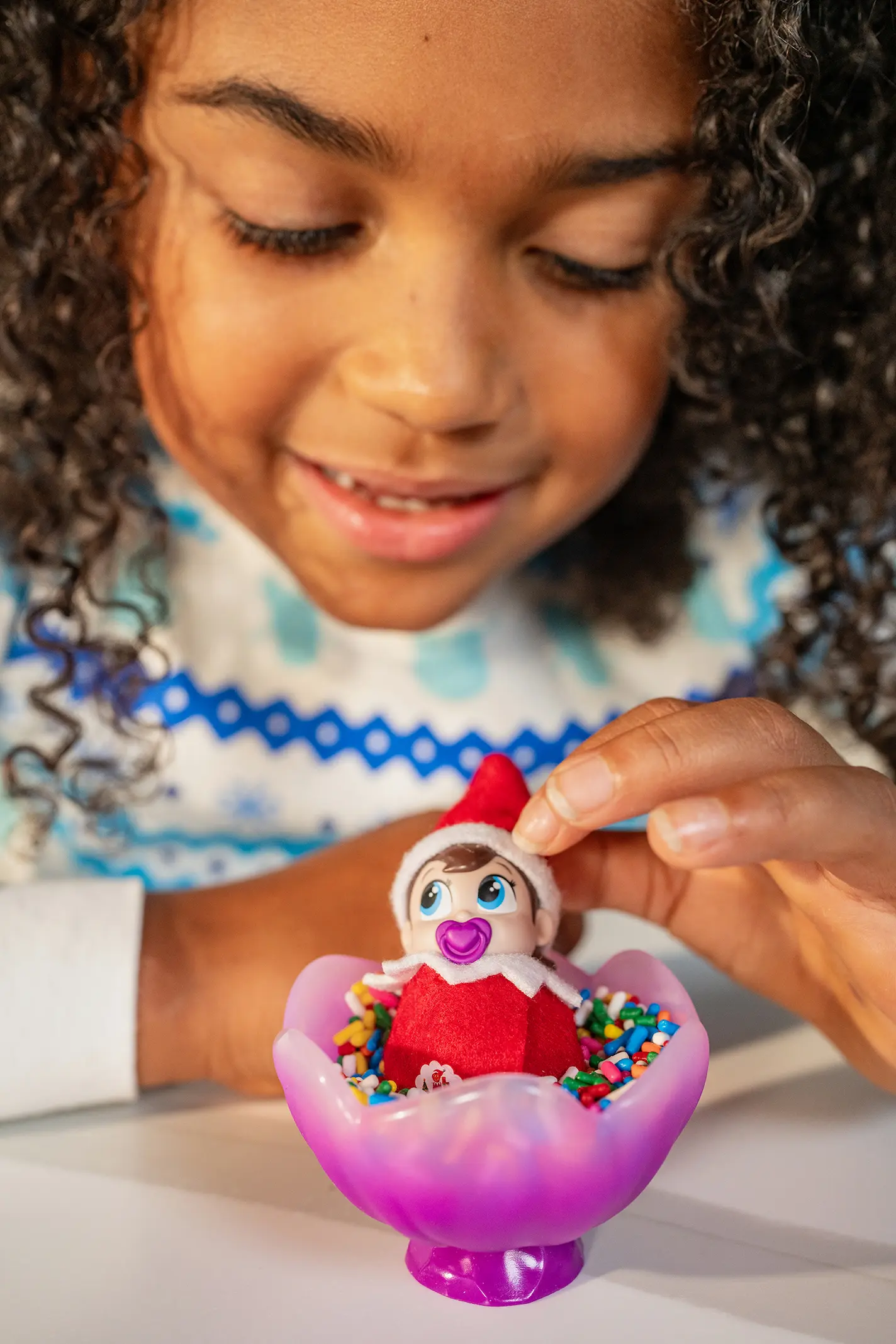 A young girl plays with a Frost Pips elf baby