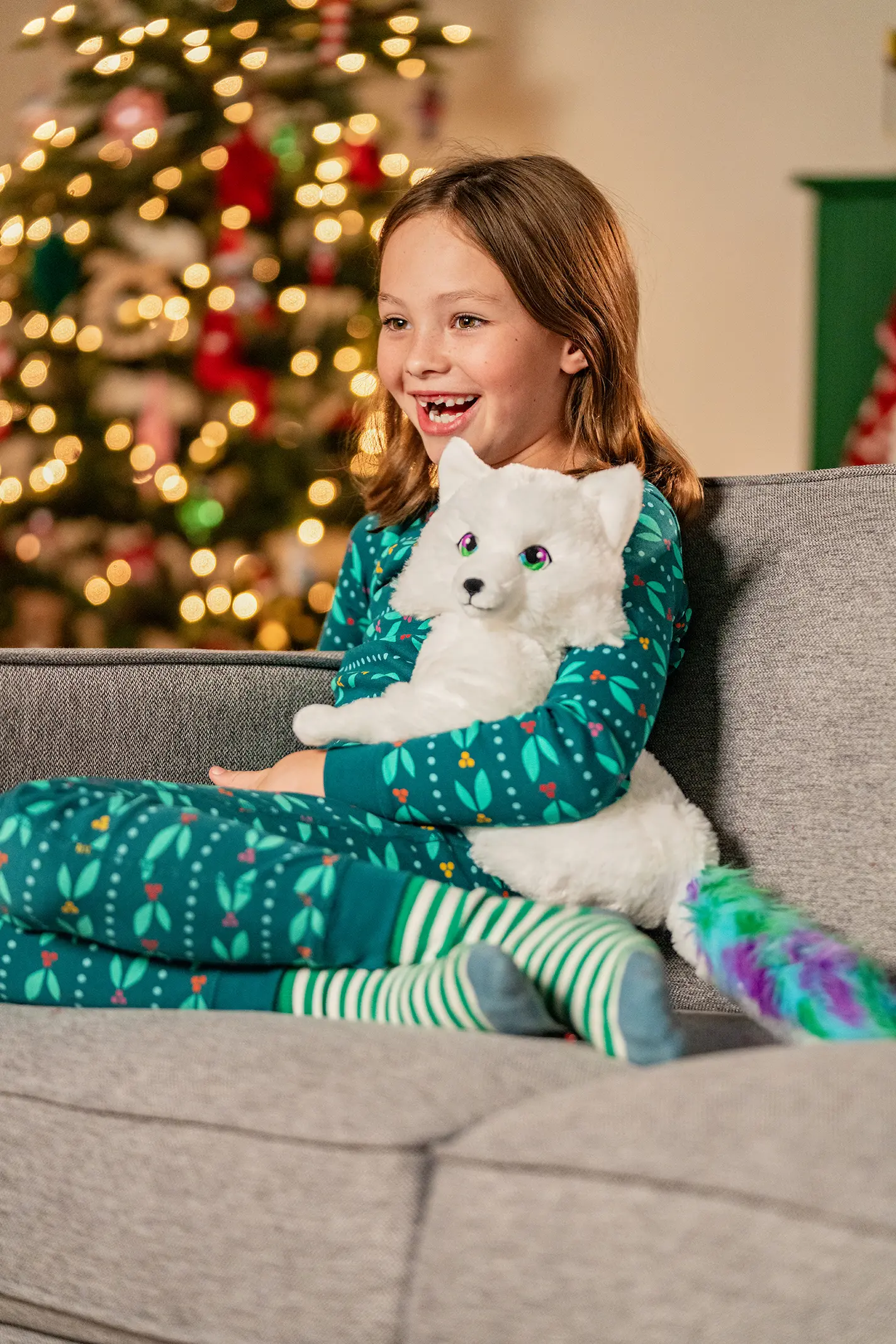 A young girl is pictured snuggling her Noorah while sitting on a sofa