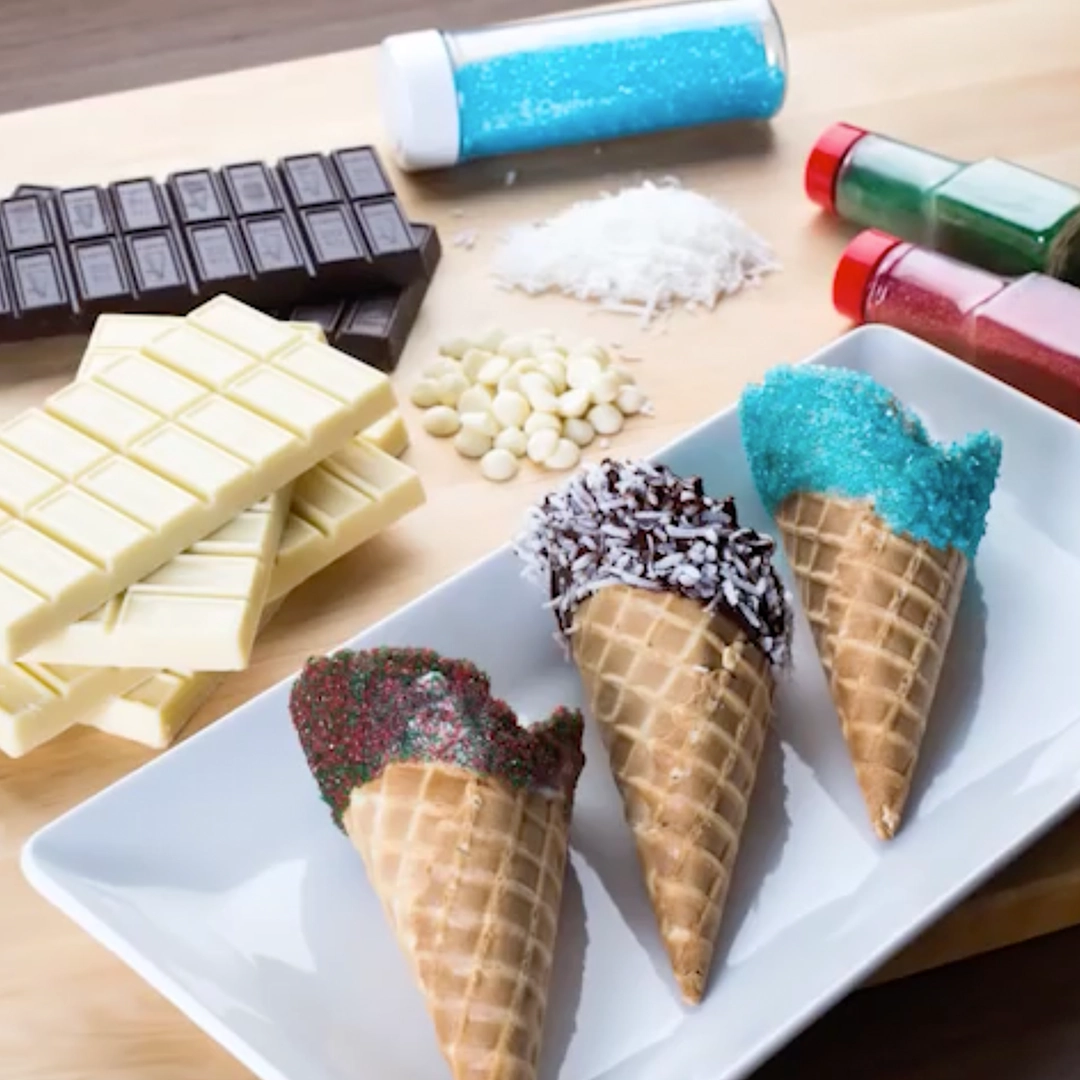 A still of 3 chocolate dipped ice cream cones from the YouTube recipe video. Each are decorated for optimal seasonal sweetness.