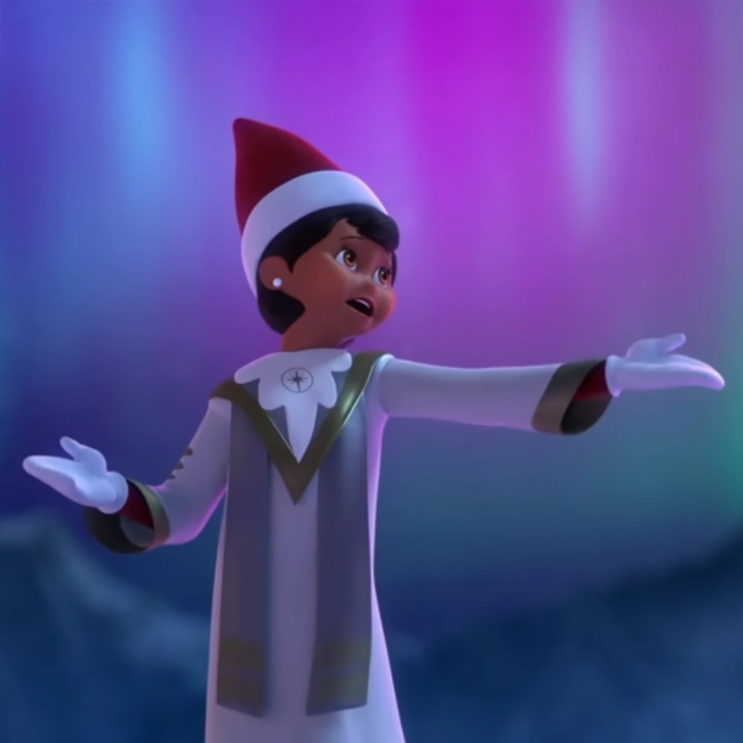 A still from the performance of "Christmas is Here!" from the Elf Pets Arctic Fox animated special. This particular still shows a Scout Elf from the choir singing a note with arm outstretched. The background shows a blurred mountain range and the Northern Lights overhead.
