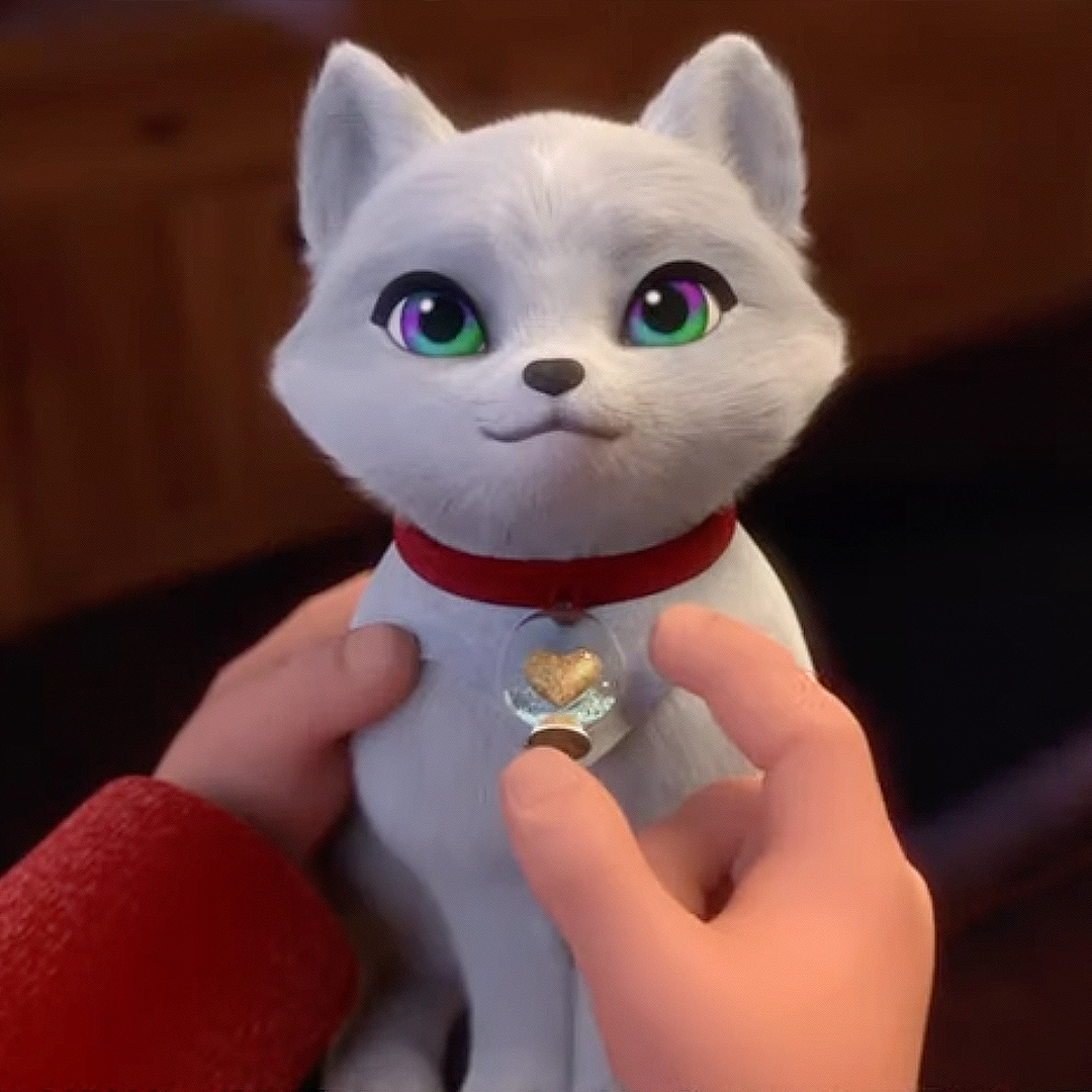 A still from "Elf Pets: A Fox Cub's Christmas Tale" trailer on YouTube, showing an Elf Pets Arctic Fox cub with his charm. He is being held by Michael, the protagonist in the film.