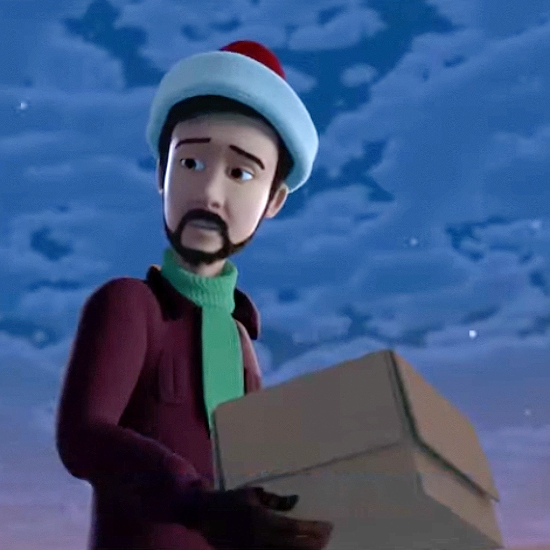 A still of Jonah wearing a Santa's hat and carrying a cardboard box from the Elf Pets: Santa's St. Bernards Save Christmas animated special.