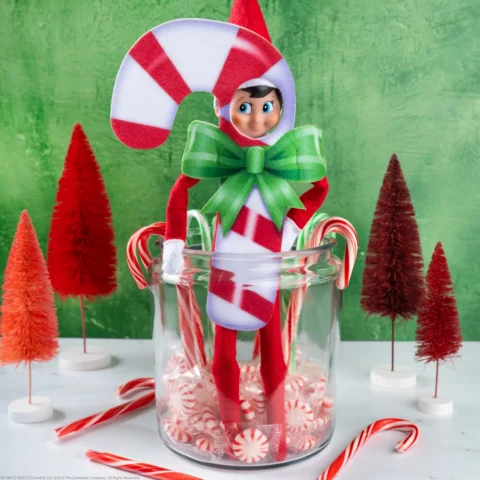 The Elf on the Shelf wearing a candy cane costume