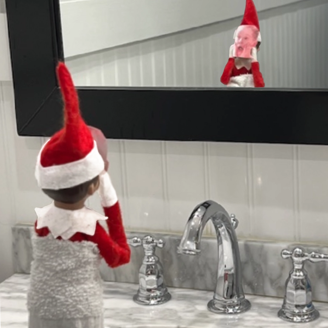 A boy Scout Elf® is wearing a print-out mask of Kevin McAllister from Home Alone.