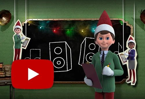 Mister Mittens holding a clipboard and pencil while standing in front of a chalkboard. On the chalkboard are drawings of speakers and music notes. To the left of the chalkboard is a paper cutout of Mr. Mittens holding a clipboard and pencil dangling from white strings. To the right of the chalkboard is a paper cutout of Professor Peppermint holding a clipboard and pencil dangling from white string. The YouTube logo is in the bottom left.