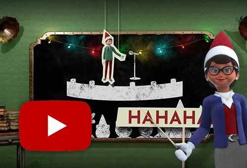 Professor Peppermint standing in front of a chalkboard holding a white pointer towards the center of it. On the chalkboard is a drawing of a stage with the silhouettes of elves and other north pole friends sitting in front of it. On the stage is the drawing of a microphone stand. In front of the microphone is a paper cutout of Mister Mittens dangling from two pieces of white string. Behind Professor Peppermint to the bottom left is a paper cutout on a stick that says HAHAHA. The YouTube logo is in the bottom left.