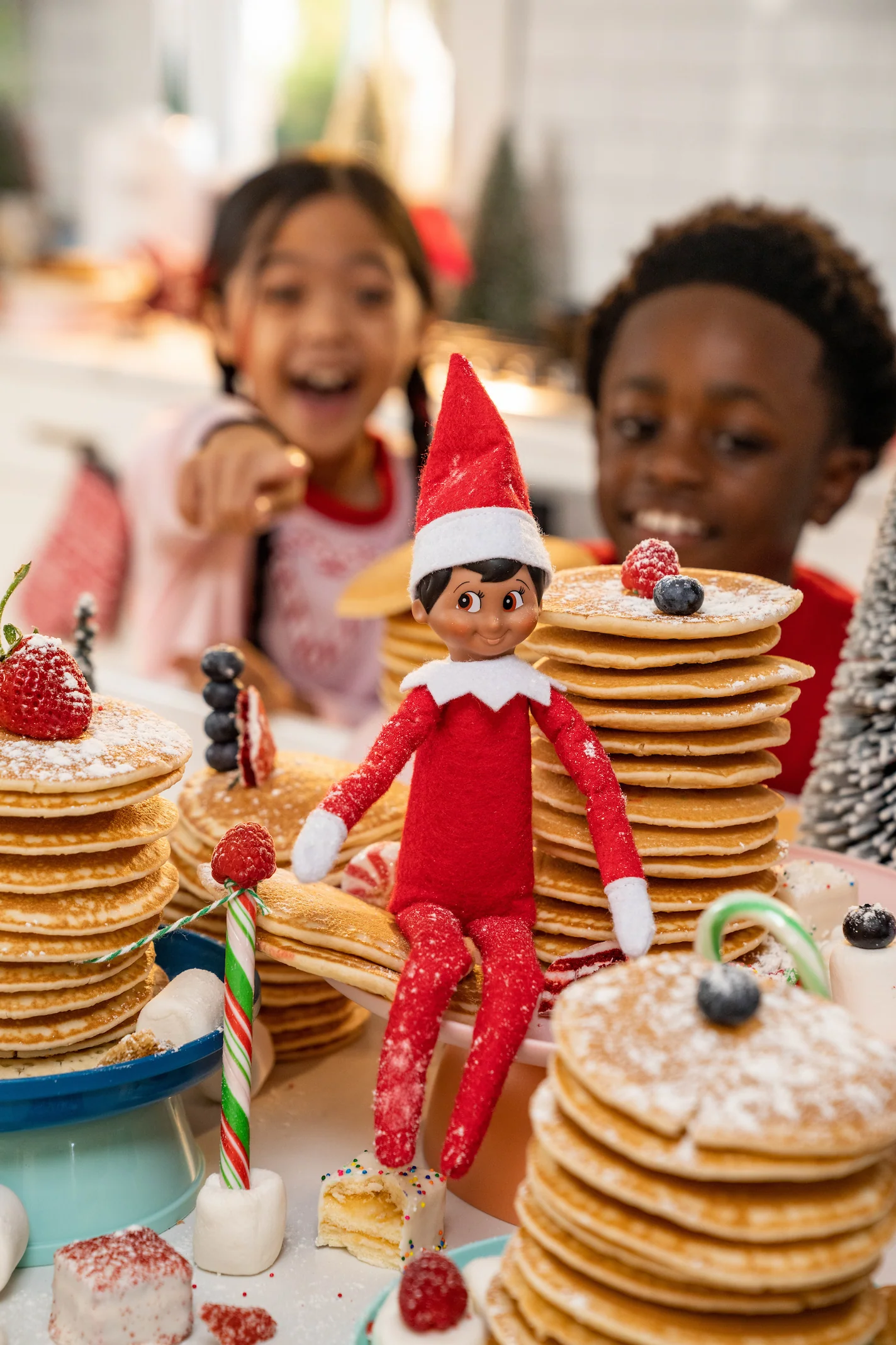 A boy and a girl are surprised with a pancake breakfast from their elf