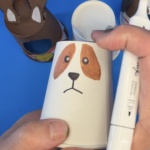 Closeup of the Saint Bernard pup's eye being drawn on a paper cup
