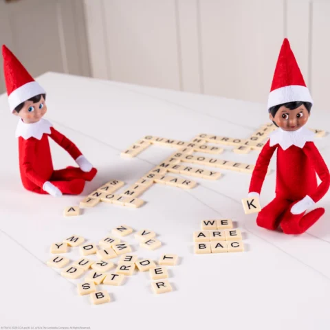 Two Scout Elves use letter tiles to create words