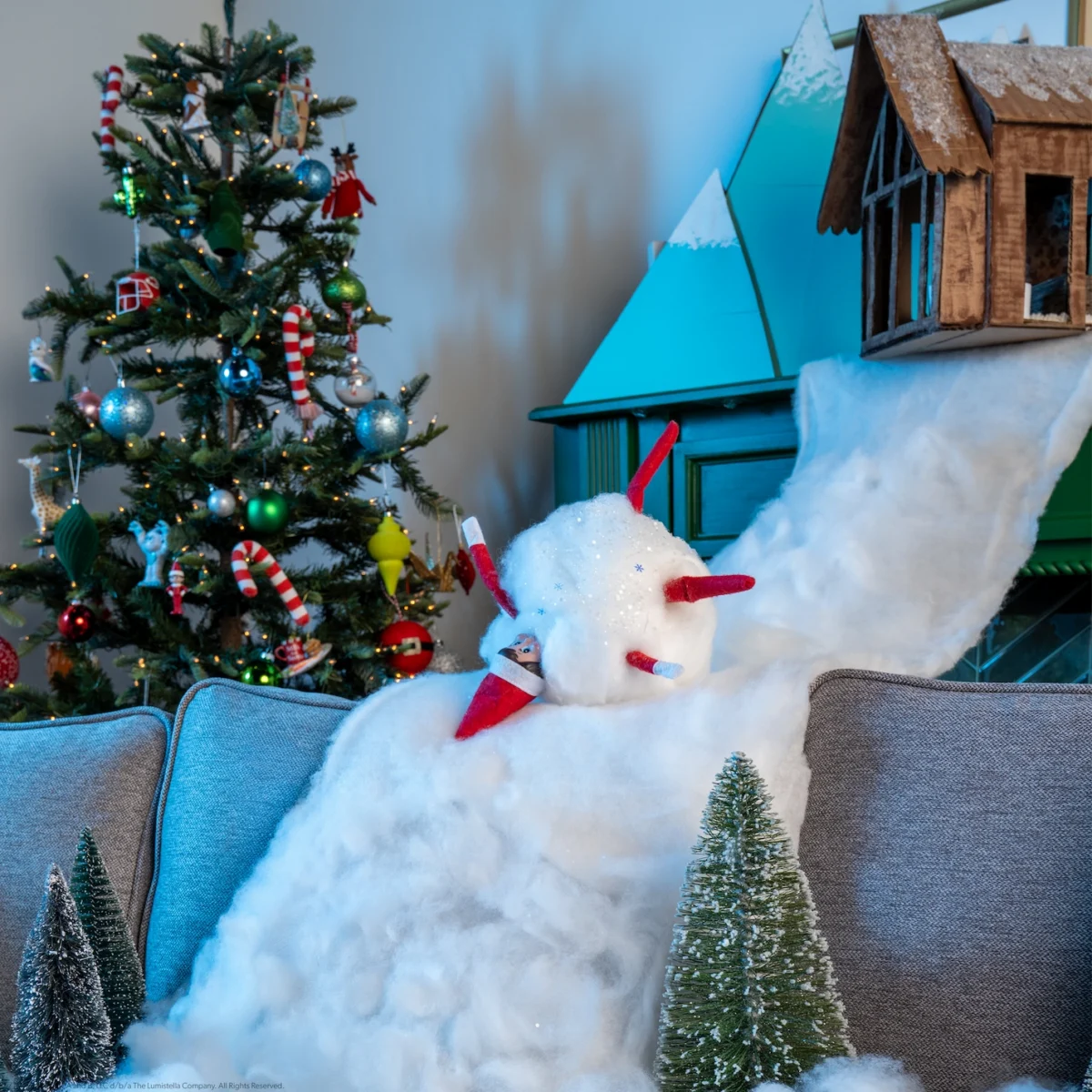 A Scout Elf appears to turn into a snowball as they tumble down a snowy hill