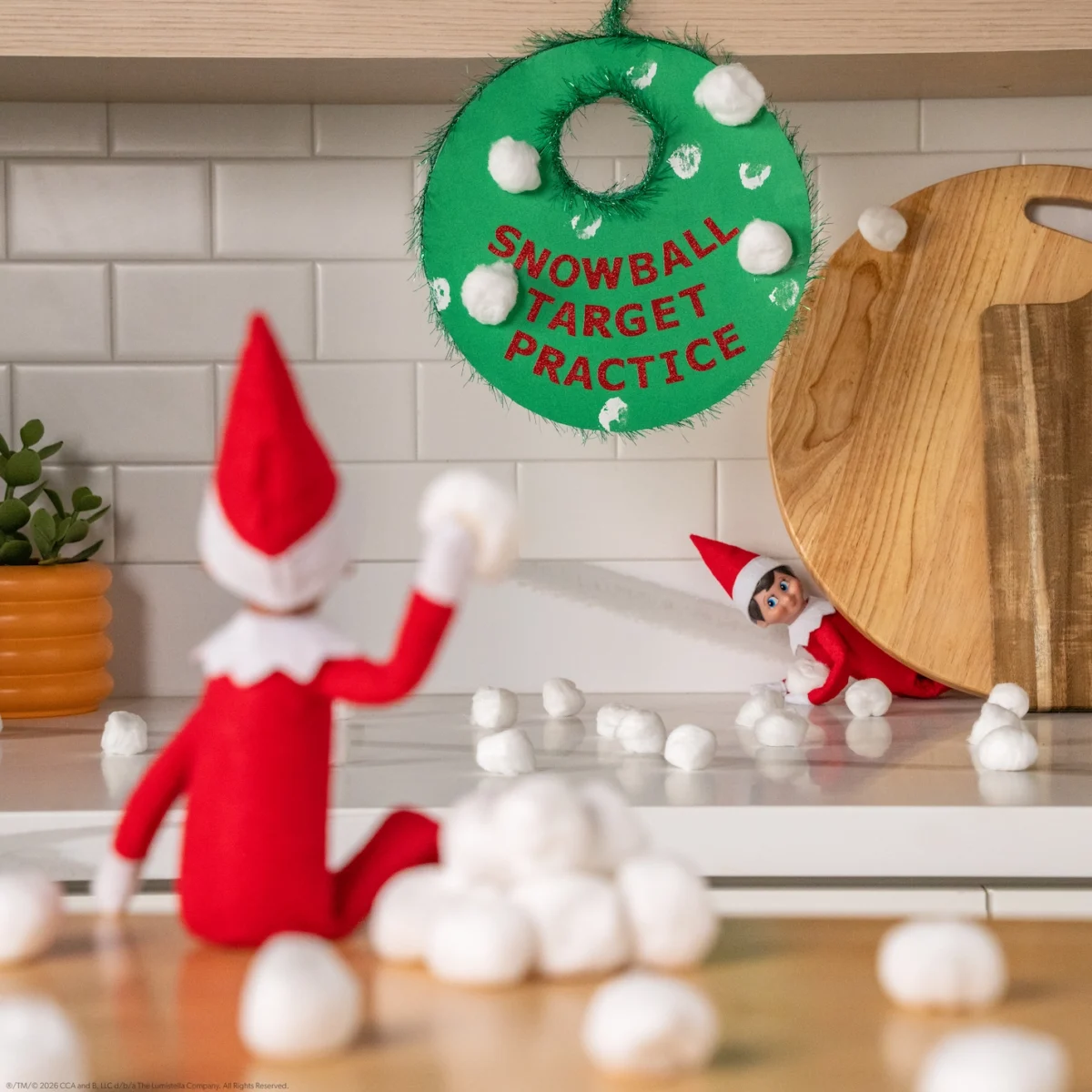 A Scout Elf throws snowballs at a green target titled Snowball Target Practice