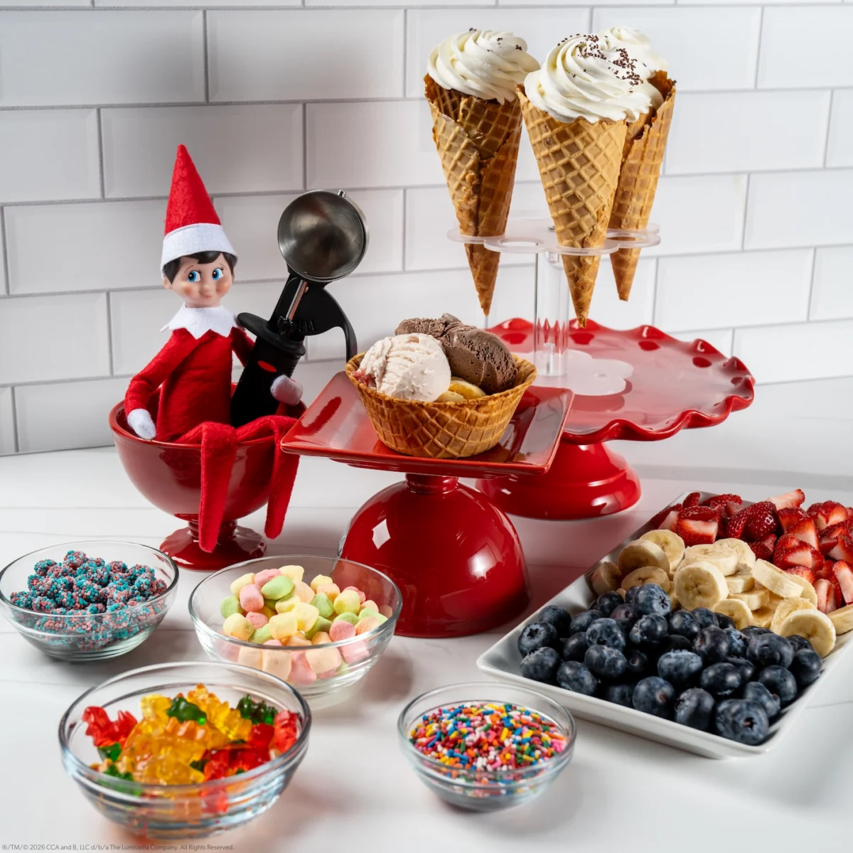 A Scout Elf sits with a spread of fixings for ice cream sundaes