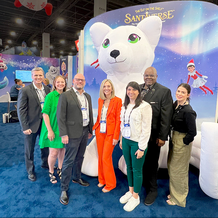 The Lumistella Company employees in front of the Santaverse booth at a licensing expo