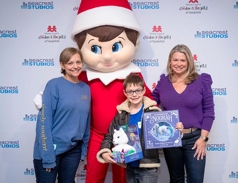 Chanda Bell, the Scout Elf mascot, and a mother and her son holding a the Extraordinary Noorah book and Noorah Plush