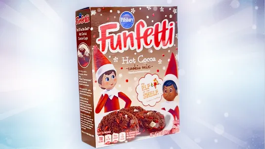 A box of Pillsbury Funfetti Hot Cocoa Cookie Mix. On the box are two illustrated Scout Elves behind a photo of the final baked cookies.