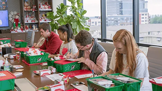 The Lumistella Company employees writing letters to put in Operation Christmas Child boxes.
