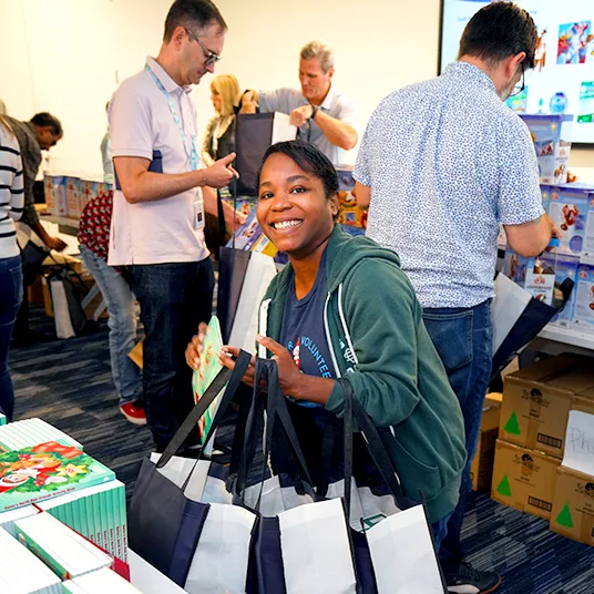 An employee gathering up gift bags at a philanthropy event