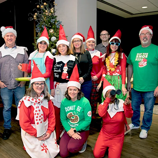 A group of The Lumistella Company employees dressed up in different Scout Elf Claus Couture outfits