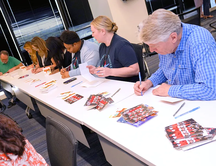 A group of The Lumistella Company employees at a writing on Scout Elf greeting cards