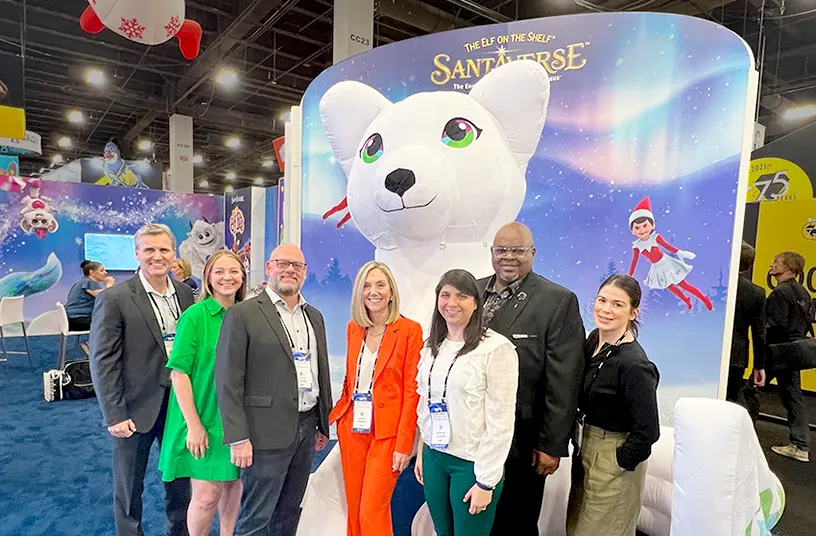 The Lumistella Company employees in front of the Santaverse booth at a licensing expo