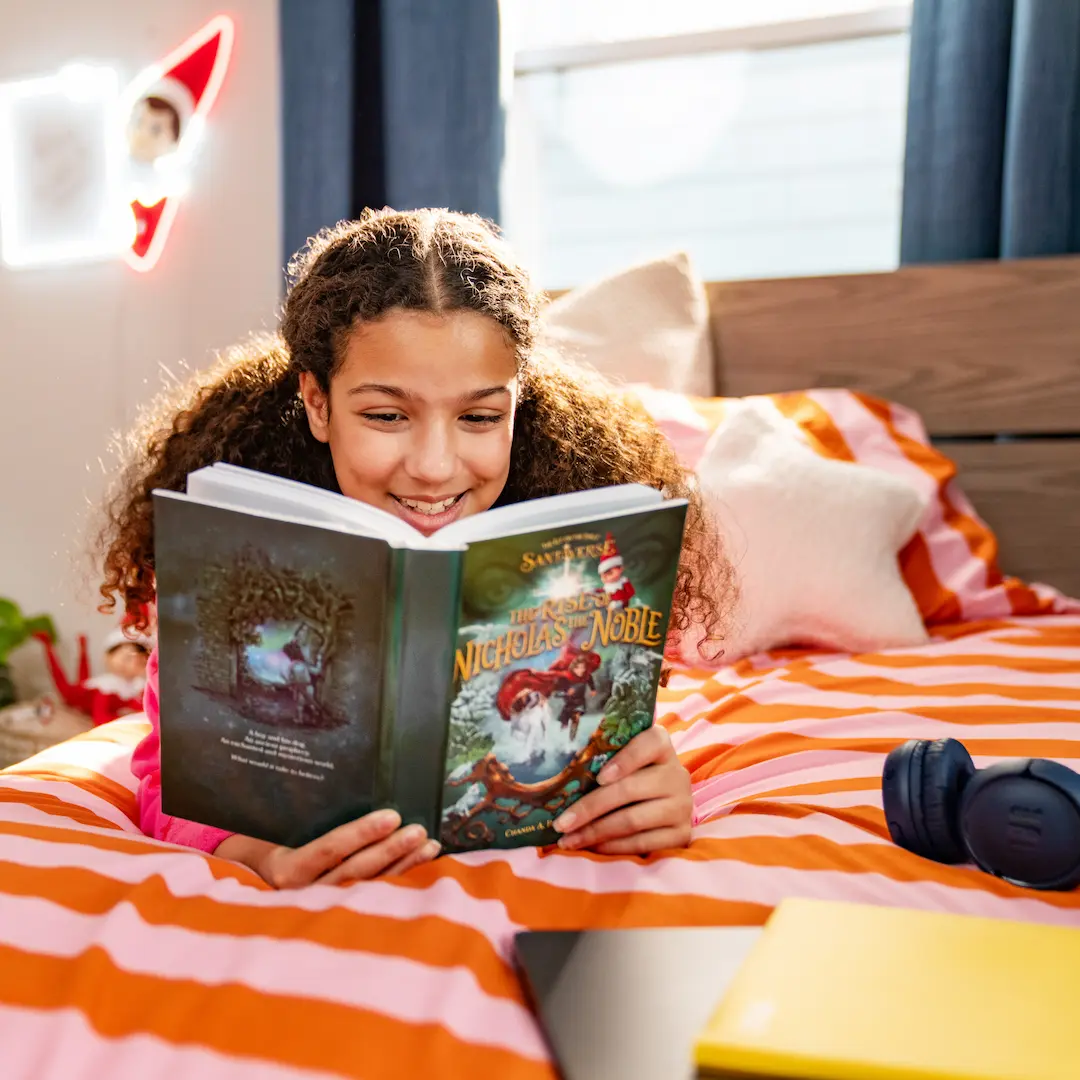 Tween girl in her bedroom reading The Rise of Nicholas the Noble novel