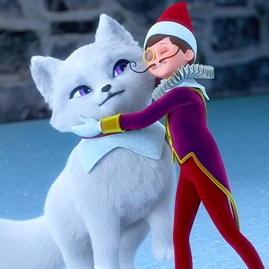 An arctic fox cub sitting on a patch of snow with a stone retaining wall in the background. Scout Elf Joe is leaning into the fox cub and hugging her neck.