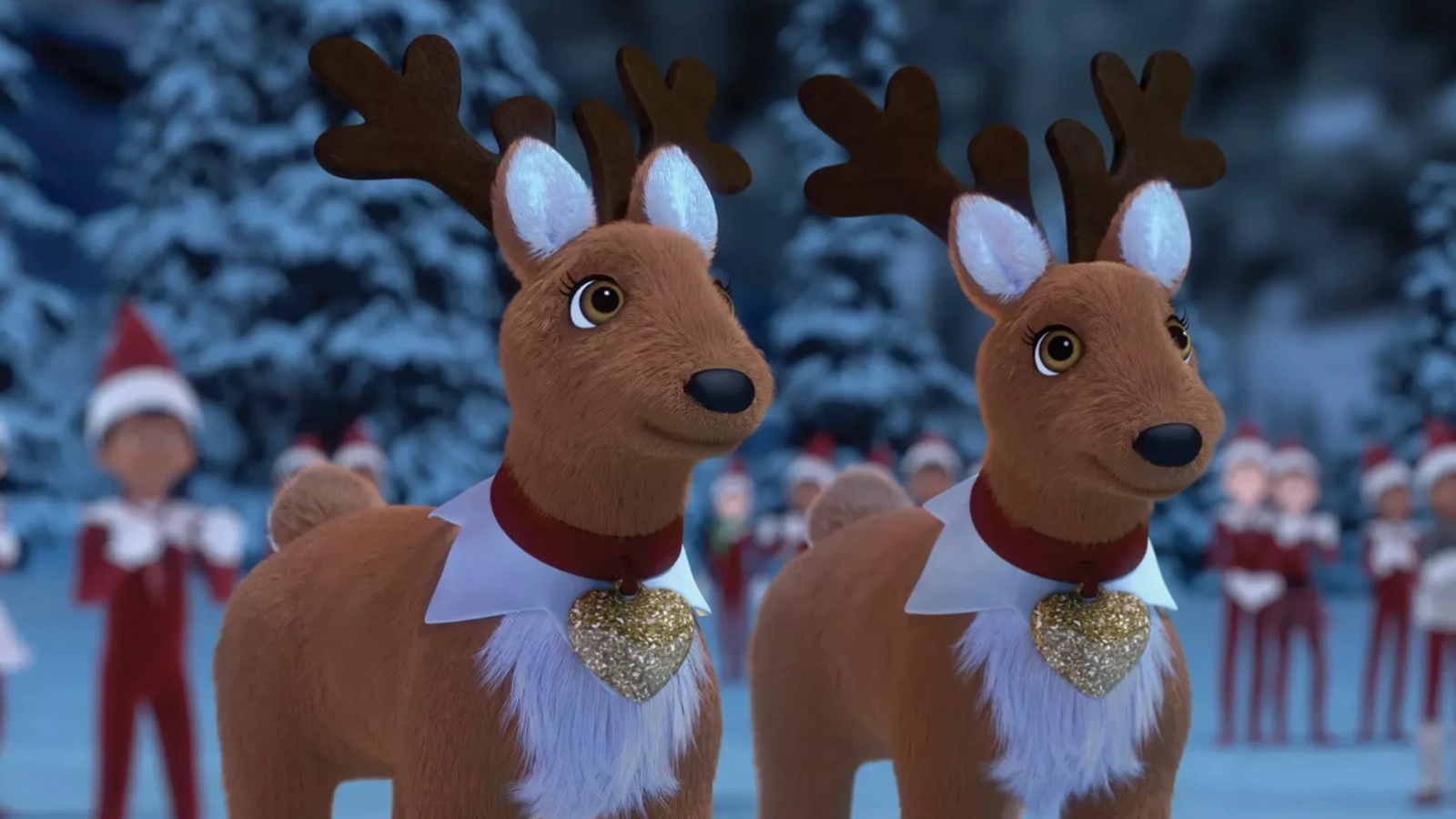A pair of Elf Pets Reindeer are standing together with pleasant looks on their faces. Scout Elves and a snowy terrain filled with snow-covered conifer trees can be seen blurred out in the background.