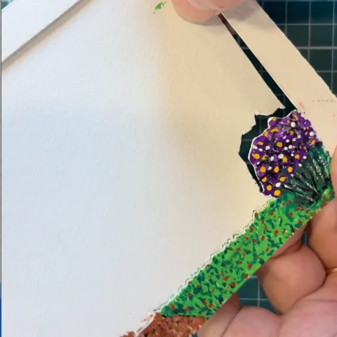 Image of painted tunnel book section being cut with X-acto knife