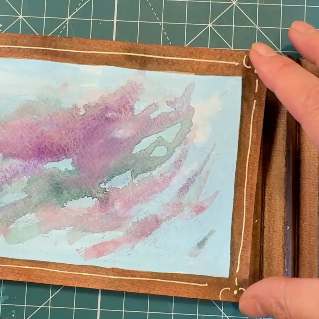 Image depicting back layer of tunnel book being glued to accordion-fold side supports